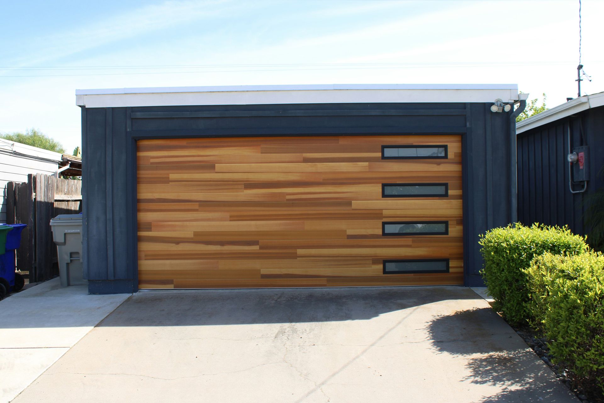 Modern garage door with wood panels and windows.